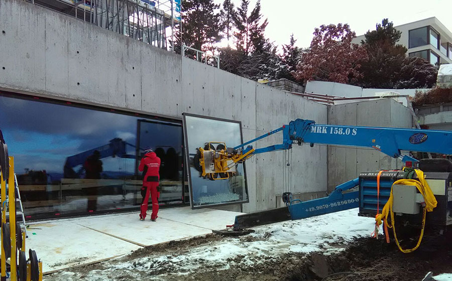 Heavydrive Kranbediener beim Setzen der Schwimmbadscheibe per Funkfernsteuerung
